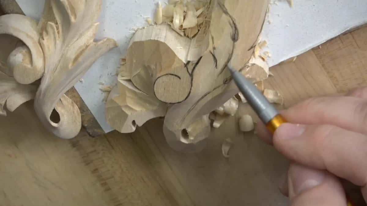 Tip of a small gouge set against the eye of the scroll.