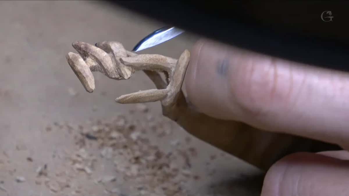 Nearly done, the cluster balances on the end of one finger, its tiny heads pointing out, a blade behind it.