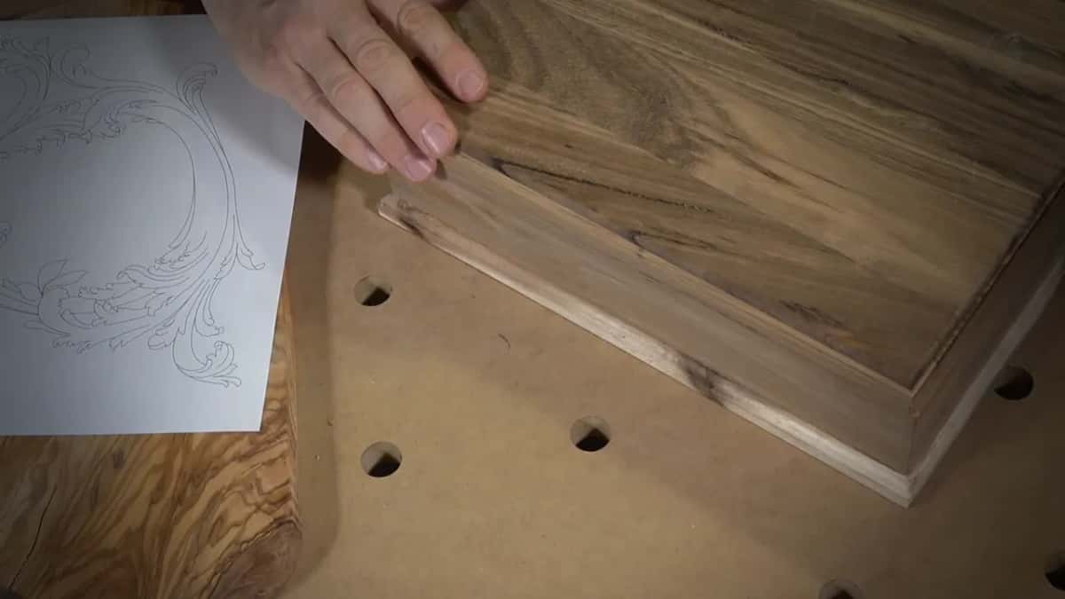 Acacia box on the bench beside the paper design and a live edge slab of olive wood waiting to be sawn