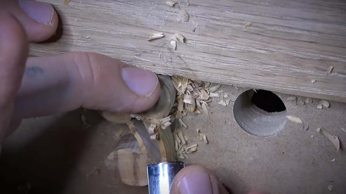 Gouge shaping one small carved olive at the edge of the board