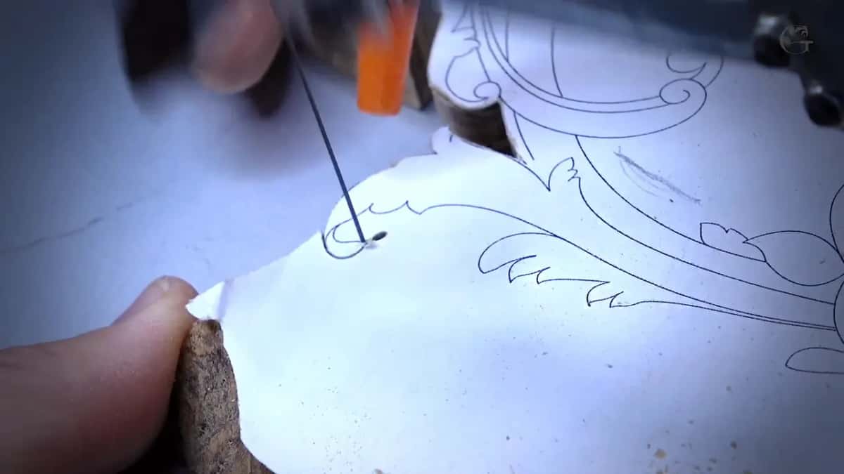 Scroll saw blade running through the papered piece