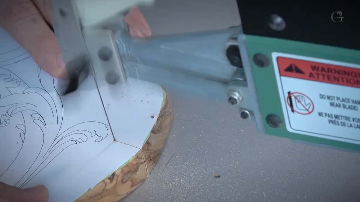 The saw's own warning sticker, telling you to keep your hands away from the blade, right beside my fingers