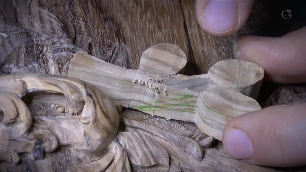 Three sawn olives on one blank, green pencil along the stem, held just above the lid