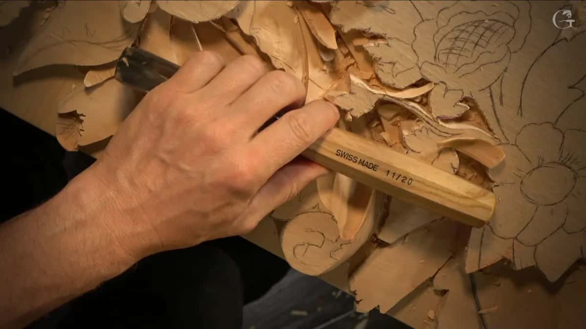 Swiss Made handle stamped eleven twenty, held over the half carved panel