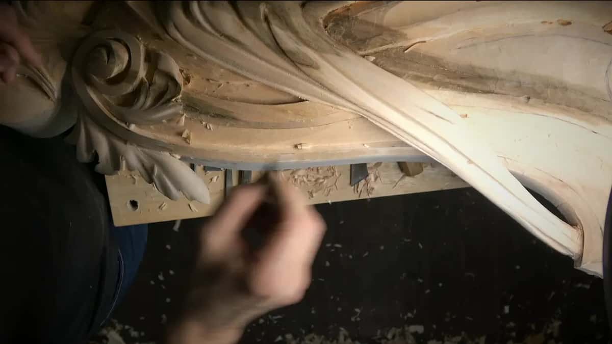 The scraper Scraper blade under the corbel edge, carved acanthus above it
