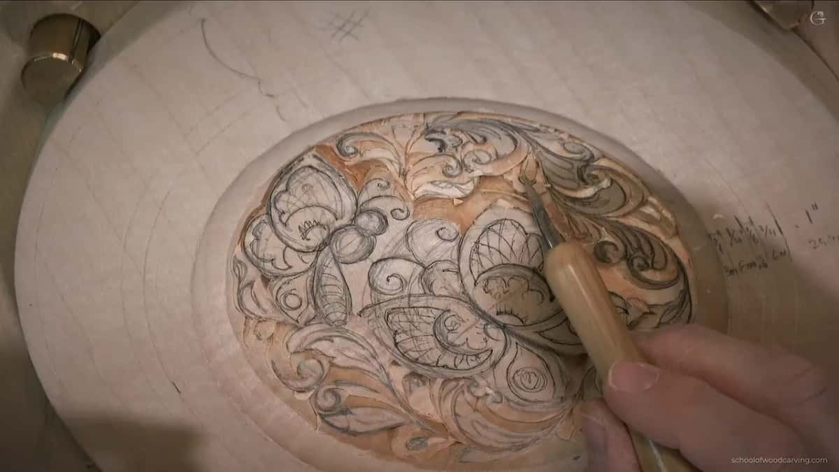 Almost upright, the knife rests its tip between two pencil lines on a curl