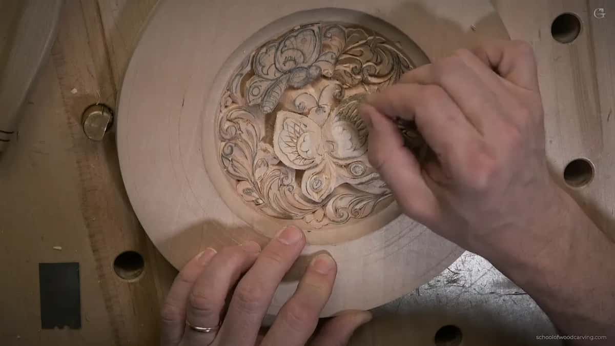 Fingertips keep the plate still while the other hand works at a curl near the dish edge