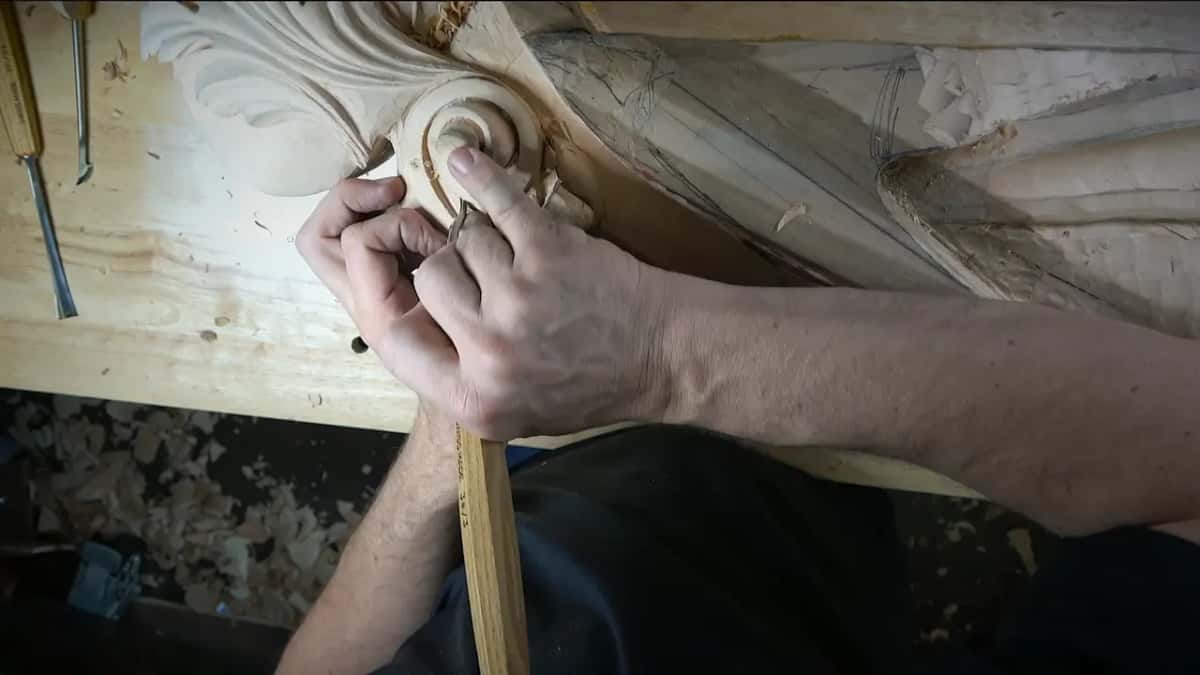 Two hands squeezed together over a small tool deep in the volute