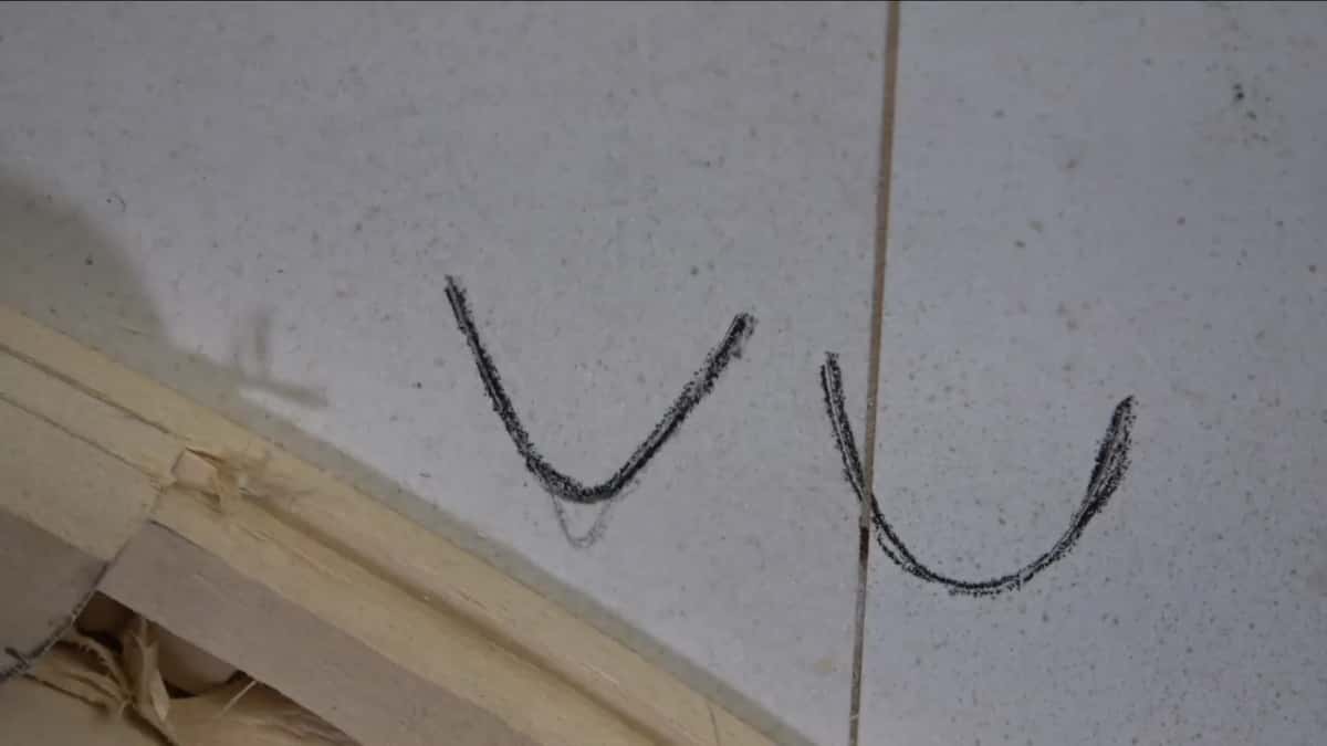 Two tool profiles inked onto the board, a letter U beside a V with a rounded foot.