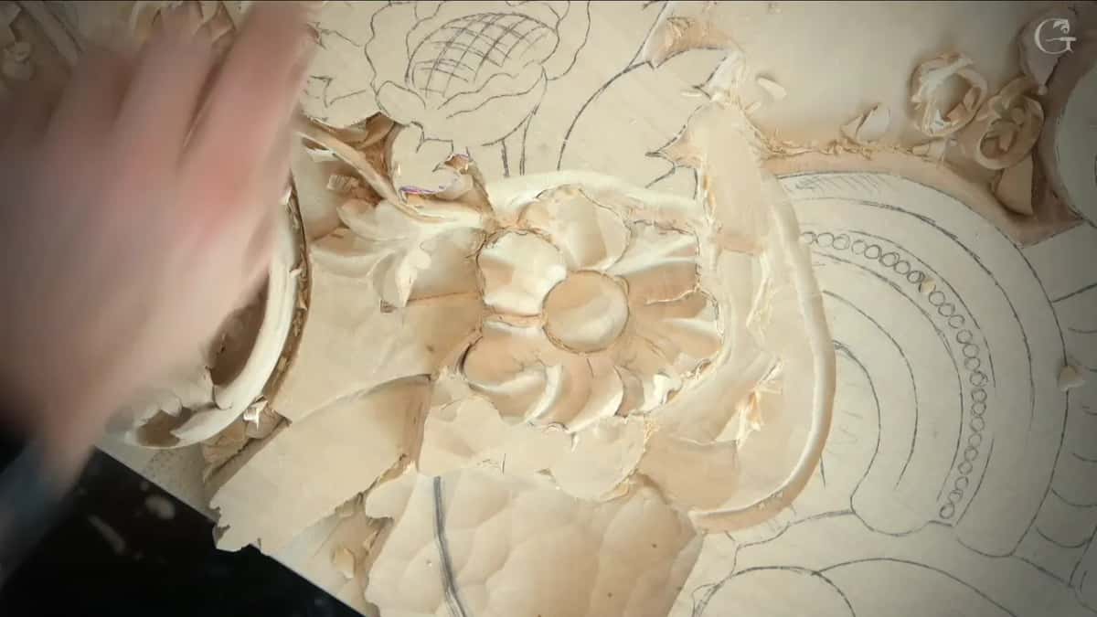 Fingertips at the left edge beside a small flower on the Venice panel, its petals swept nearly clear