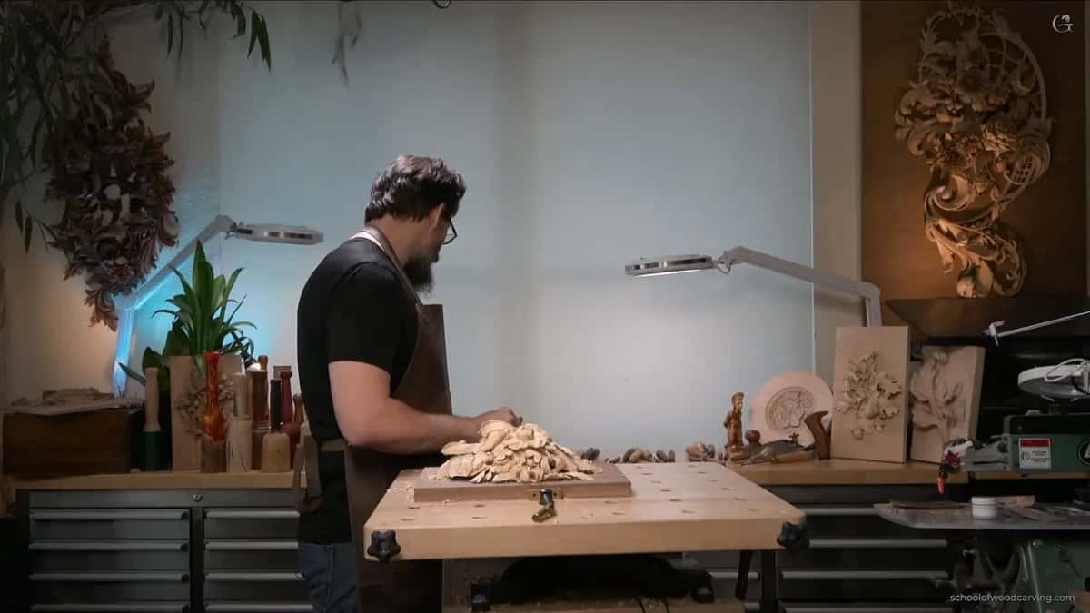Bent over the bench with his back half turned to the camera, working with a tiny back bent