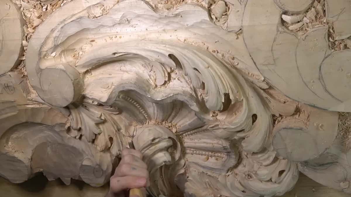 Angled view, a hand works a hollow by the shell.