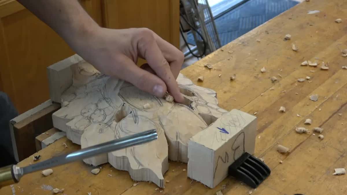 Chips scattered across the bench beside the pierced panel, with holes cut right through it