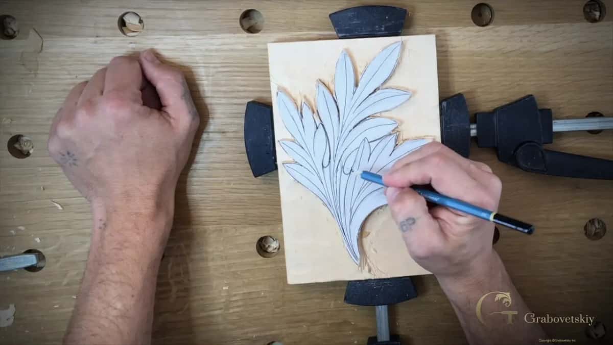 Two hands over the block with a blue pencil, working the tips of one section, which is where the five points get drawn.