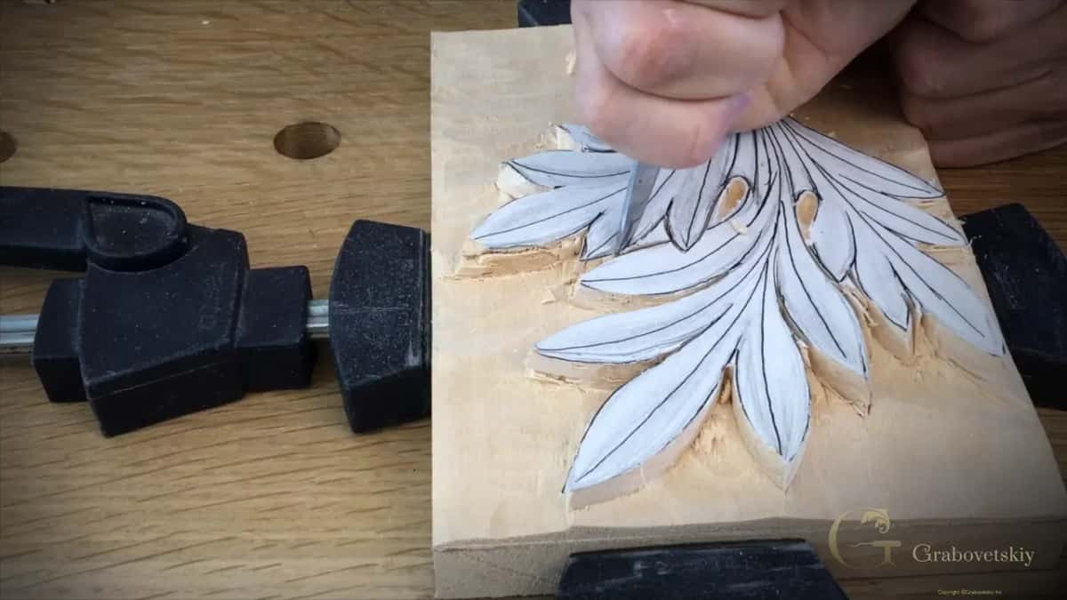 Turned ninety degrees, the same knife travels along the curved edge of a lower lobe with chips beside it.