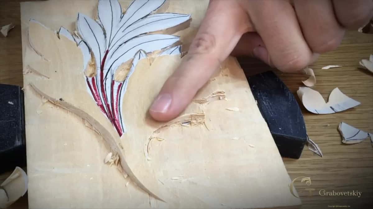 Chips scattered over the bench and the block while a finger points into the roughed hollow.