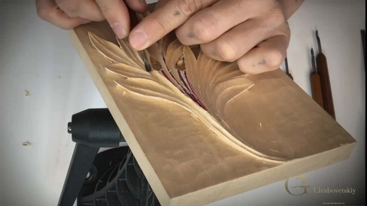 Both hands on the panel, red lines still visible at the top of the design.