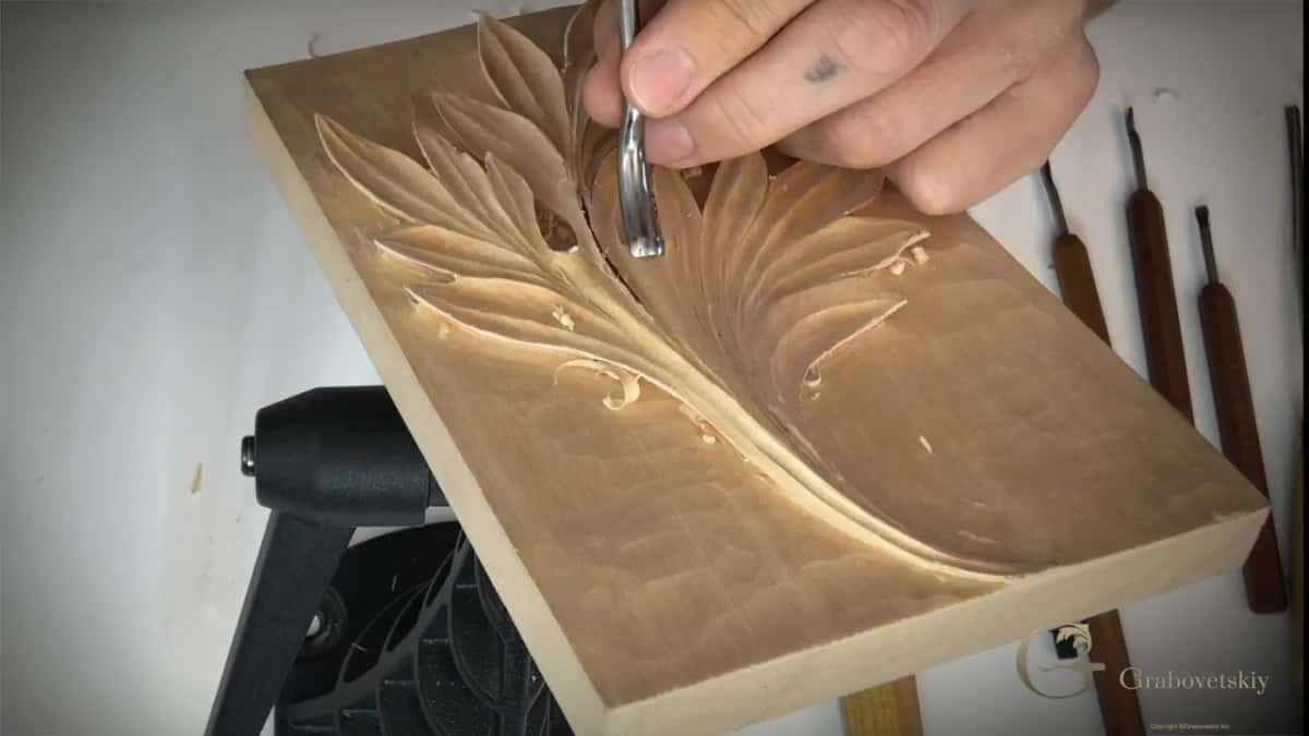 The bent blade curving in under the edge, which is how it follows round a shape a straight tool cannot.