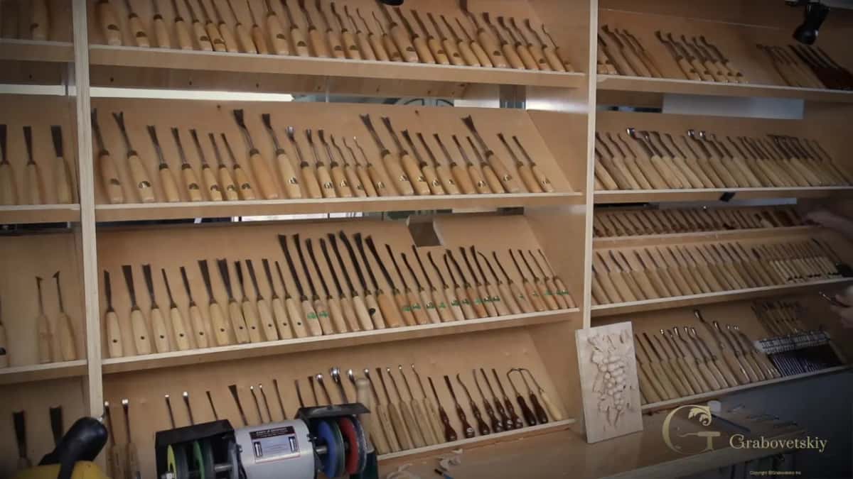 Rows of small tools standing in the wall rack behind the bench.
