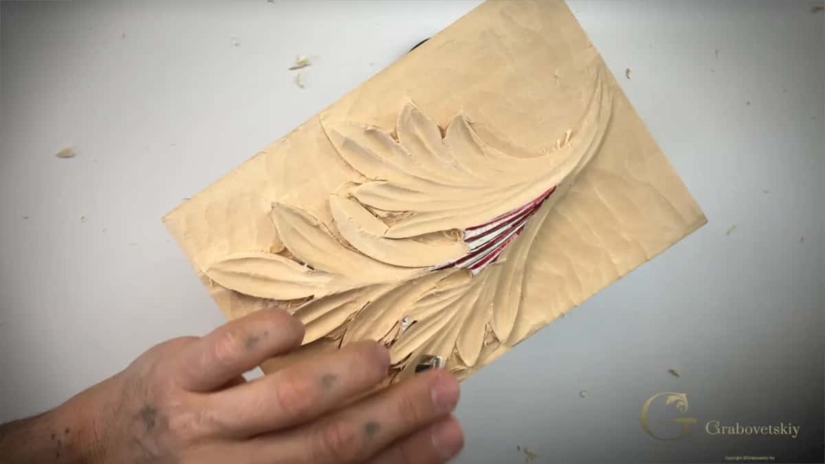 Fingers within an inch of the edge that is cutting, wrapped right around the panel for support.