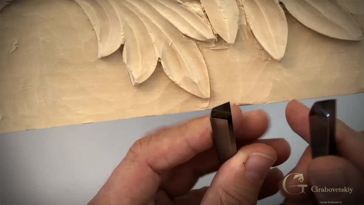 Two V tools held up end on, one in each hand, so the difference between the angles shows.