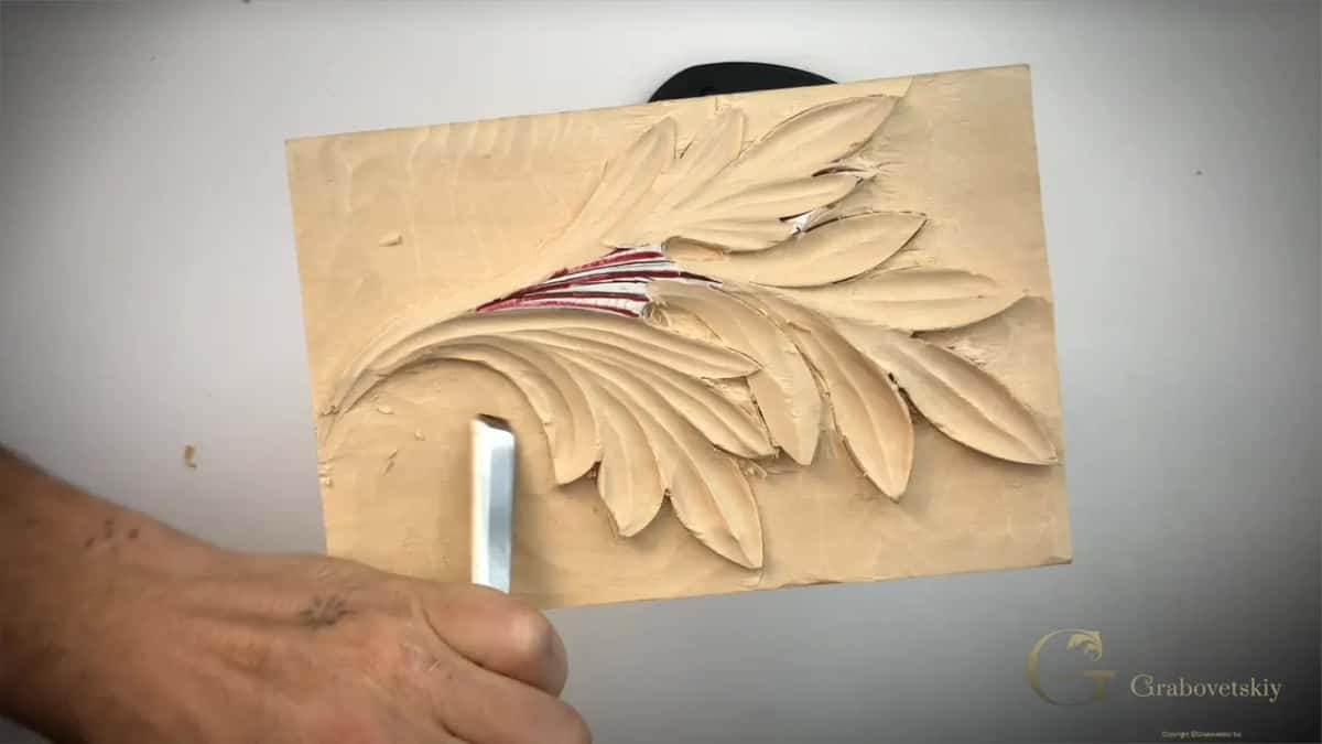 Steel blade laid almost flat against the background, reaching in under a lobe that sits low.