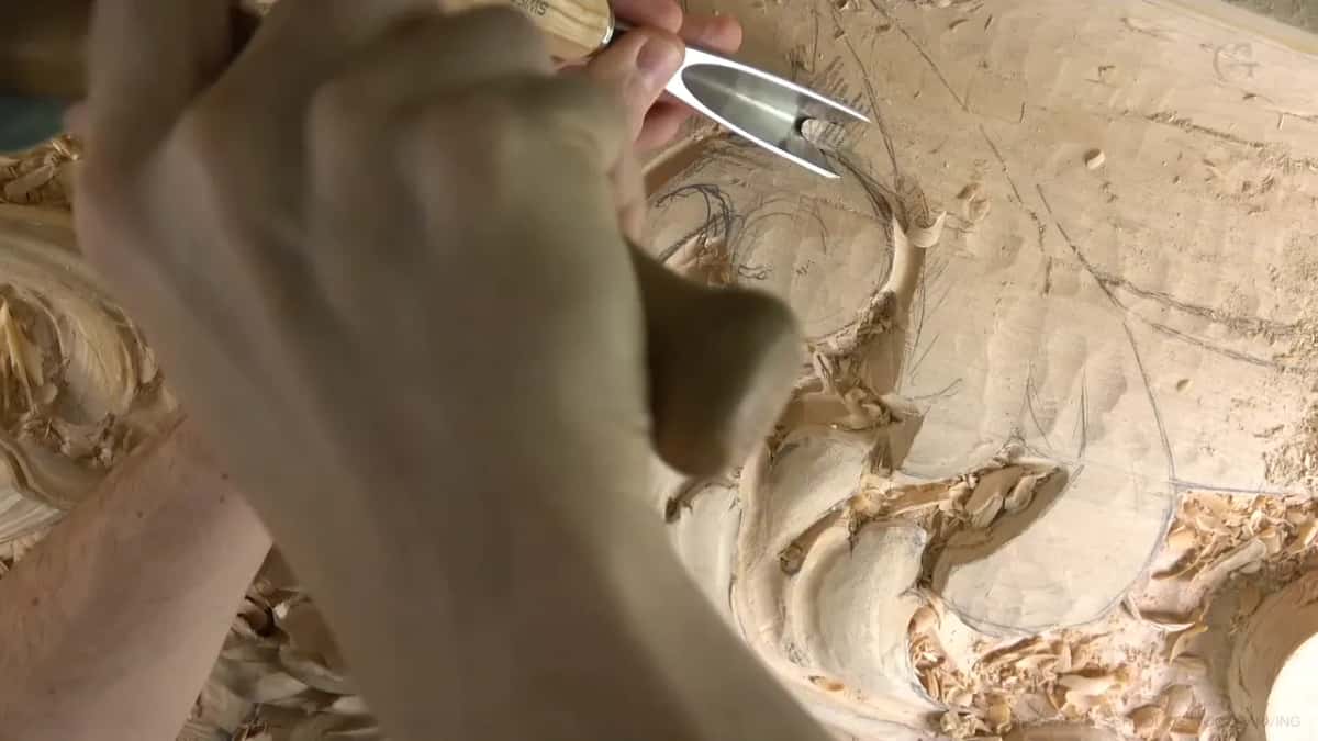 Close up of a deep U-shaped gouge going in beside the curled scrolls.