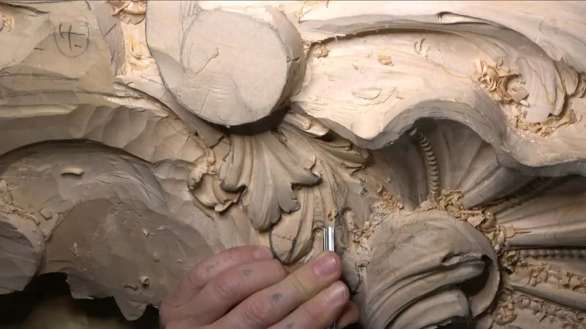 Fingers drive a gouge in beside the beaded shell.