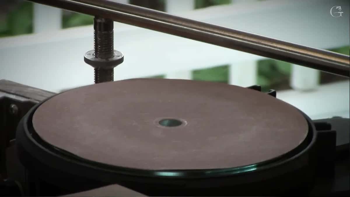 Plain brown abrasive disc mounted on the machine with the guide bar above