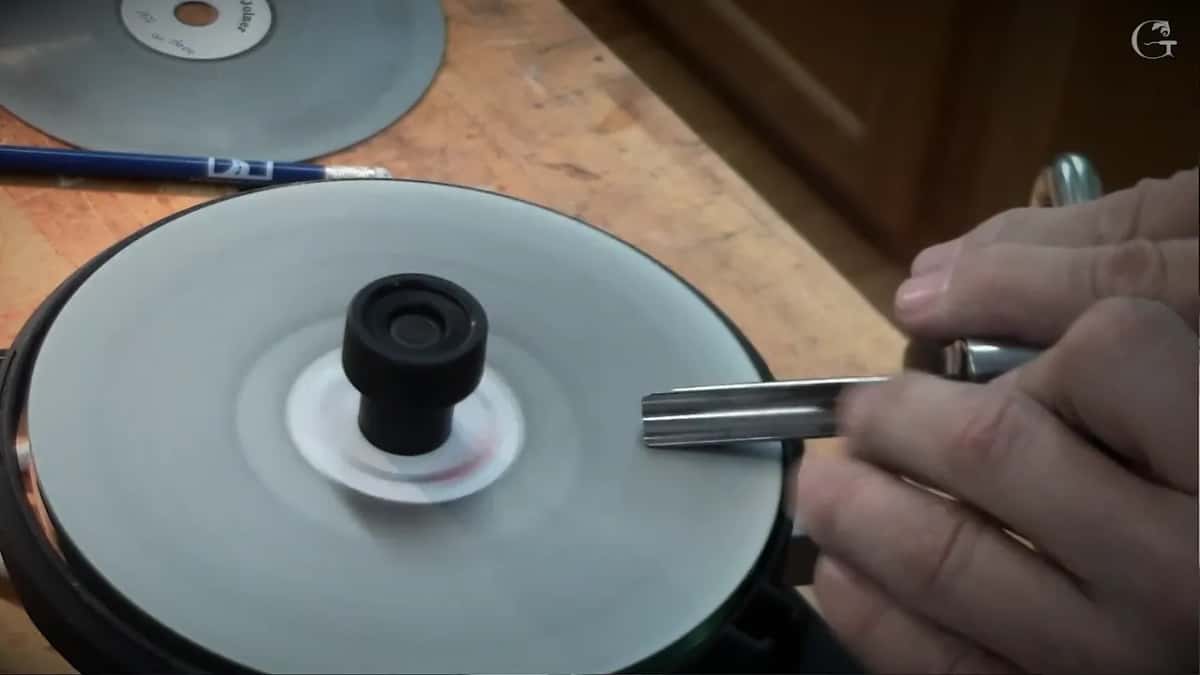 White disc spinning while a blade rides against it
