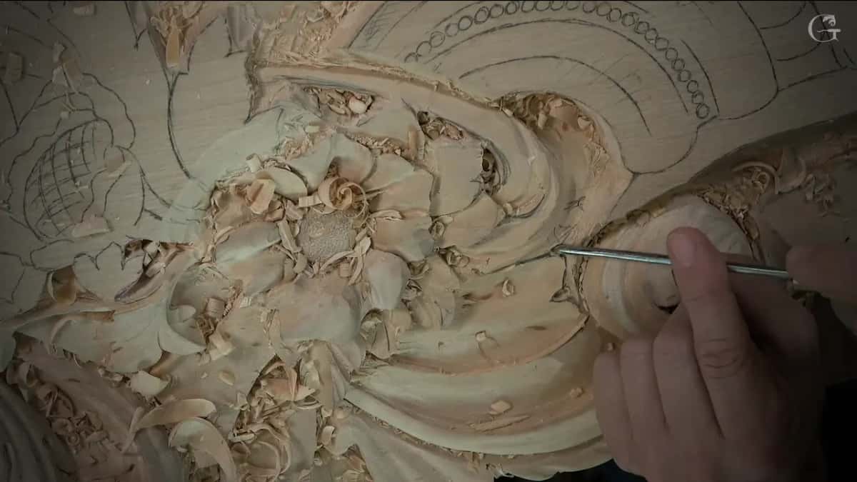 A long, slim steel shank goes into the hollow of the scroll while two fingertips guide it along