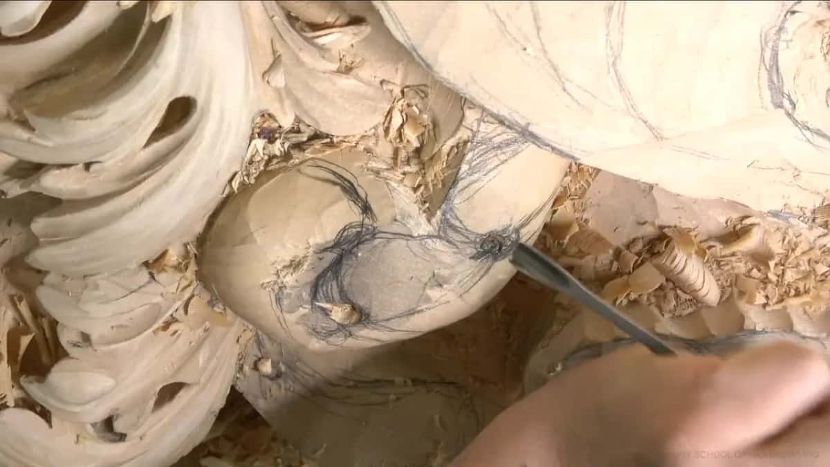 The gouge plunges straight into a round lobe marked with pencil loops.