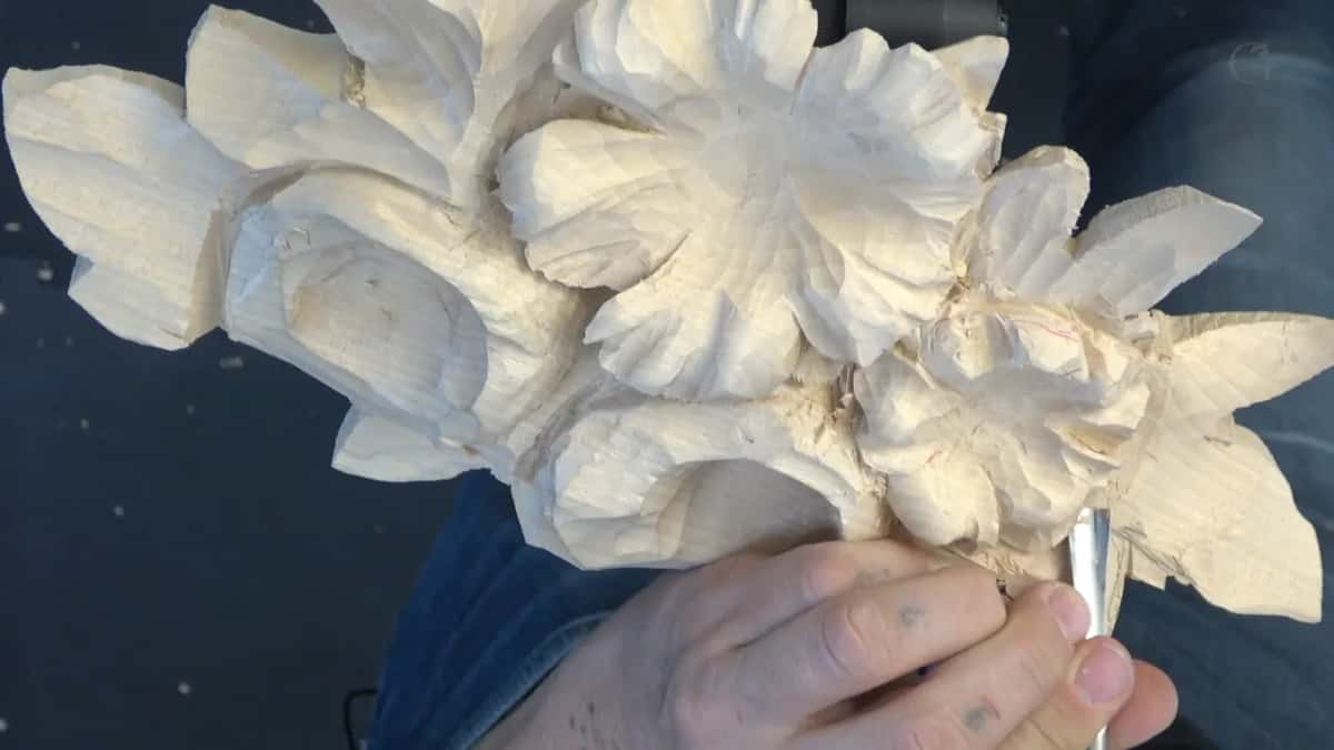 Held out over the bench mat, the flower at the centre finished enough to read as a flower at last