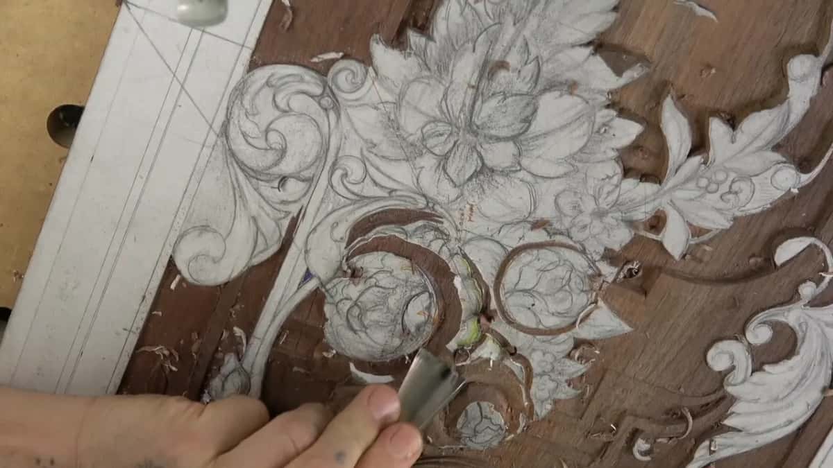 Wide bright gouge held low, its edge at the middle of the carved circle