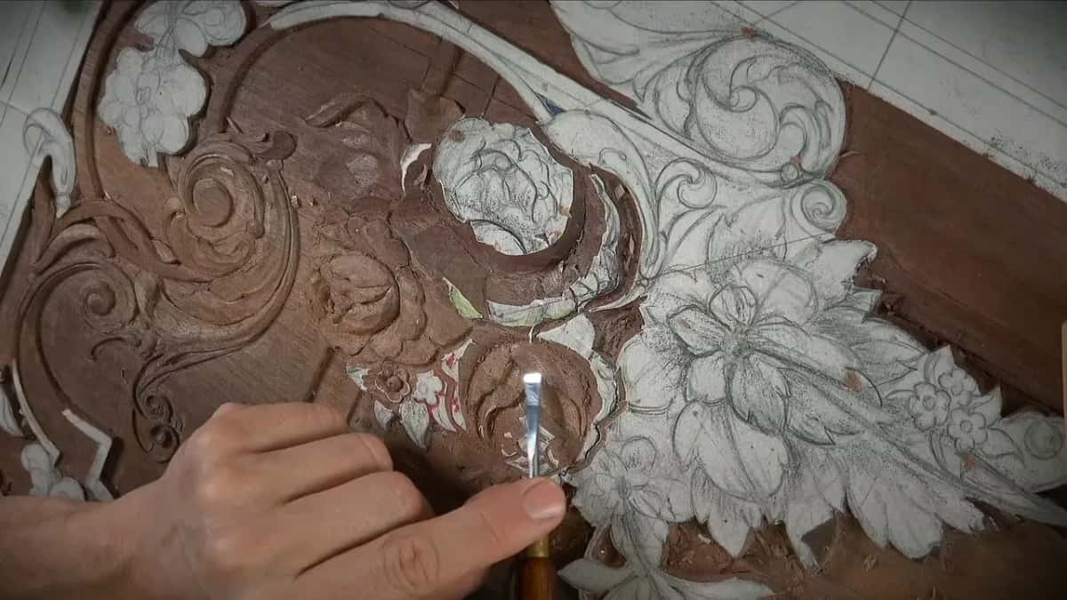 Gouge at the small carved rose, the drawn flowers crowding in from the right of the frame