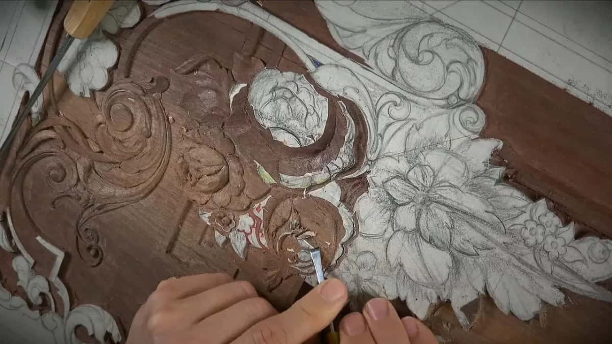 Hands working low with a slim tool