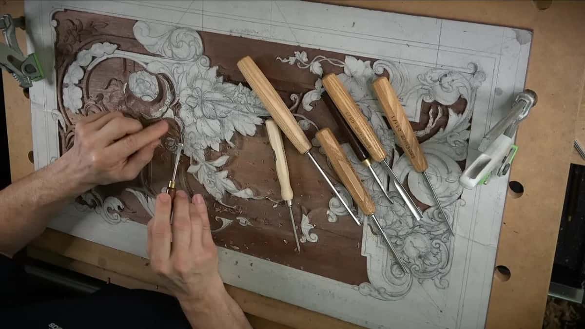 Panel from above with five gouges across it, both hands fitting a handle