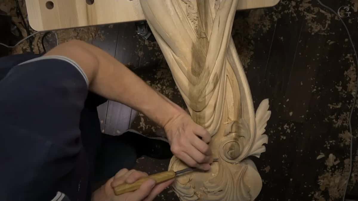 Arms reach in from the left to work the corner where the drape and the spiral come together.