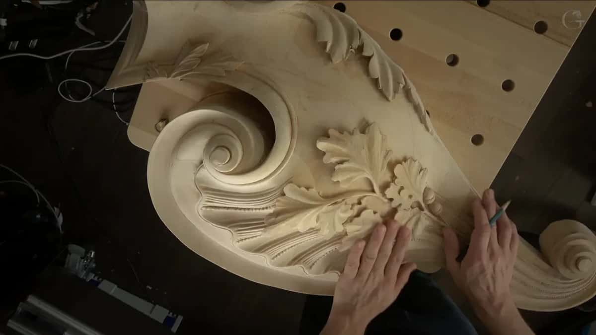 From above, the rolled spiral and its leaves on a drilled board, pencil in hand.