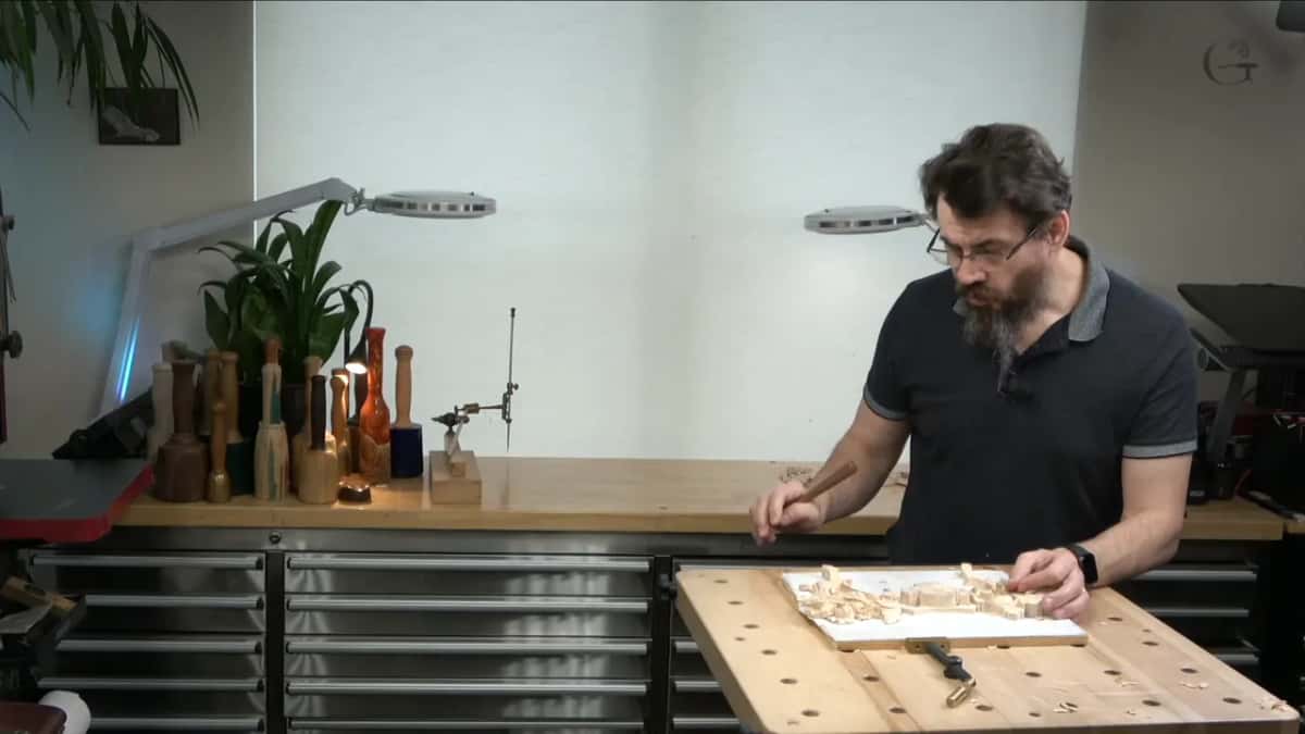 The carving under workshop lamps, lit from every direction at once