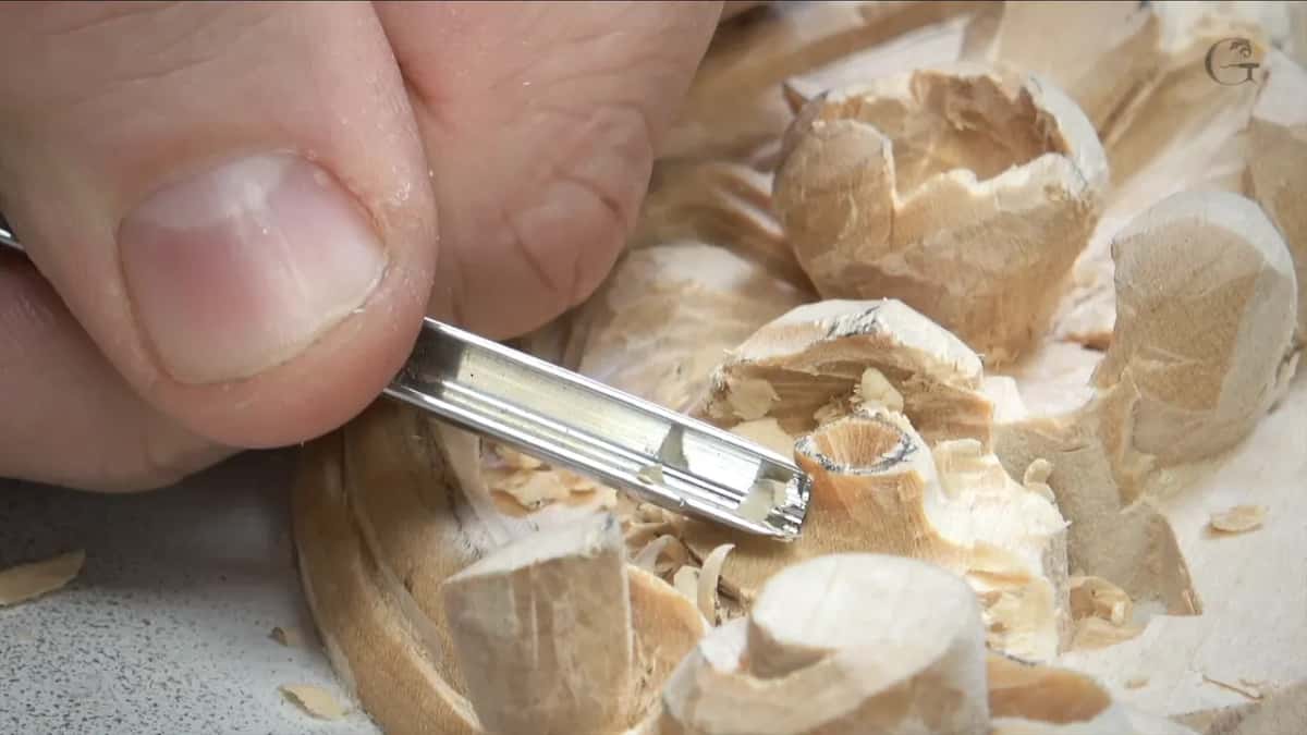 Small gouge pinched between finger and thumb at the rim