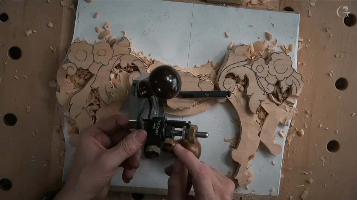 Veritas router plane held in both hands with a narrow blade fitted