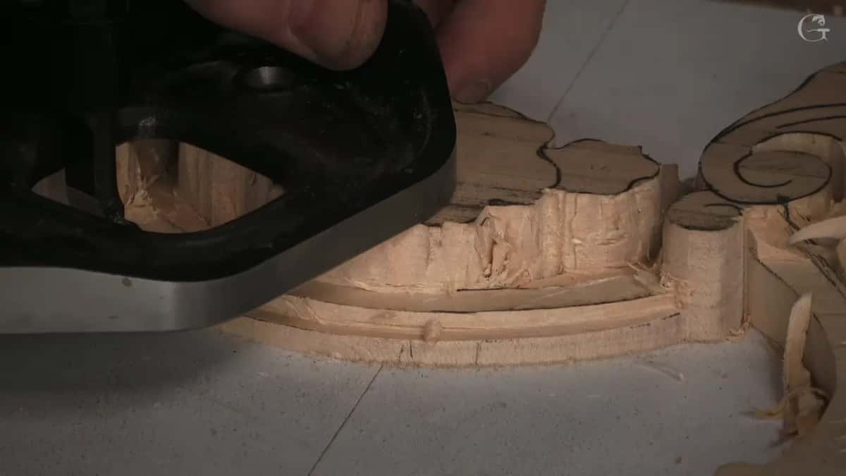 Router plane riding the molding with its blade lifting a shaving, taking the last of the depth out of the channel