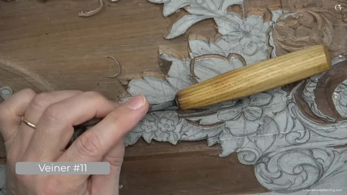 Ring on his finger, pale handle in his palm, edge against walnut.