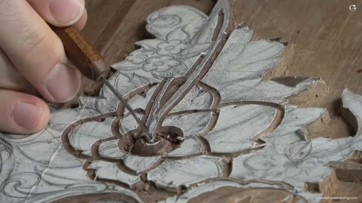 Chips lie beside the hand as the small tool works down inside.
