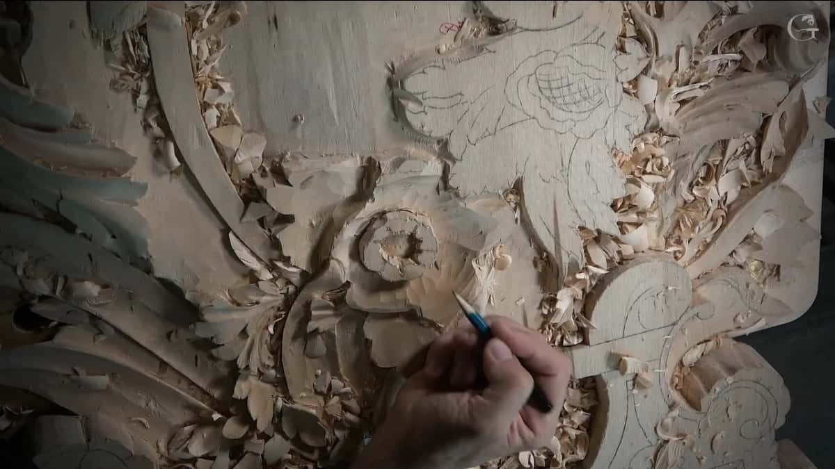 A blue pencil marks the flower middle, with pencil leaves drawn on the flat wood beside it