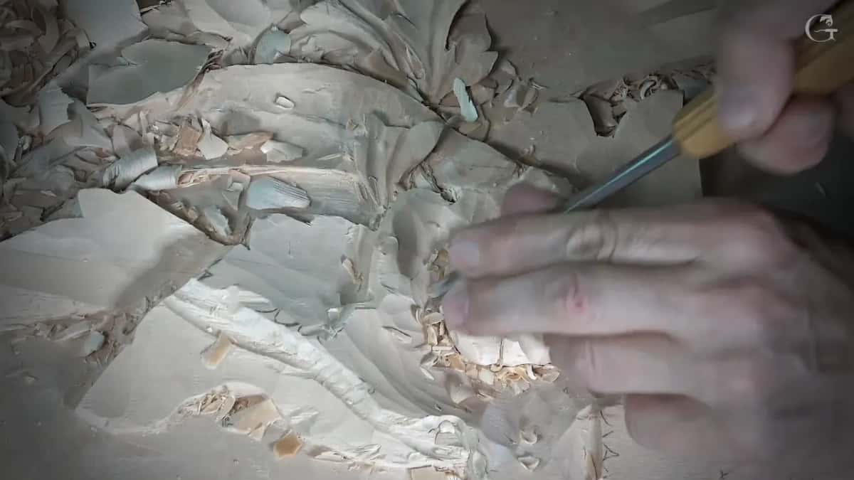 Yellow handled gouge in the petals, fingers of the left hand bracing the blade