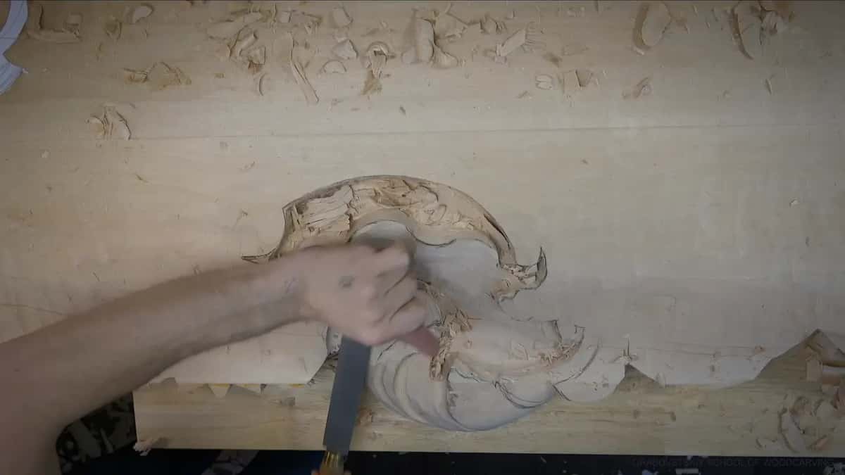 An arm reaches in from the left and holds a long flat rasp on the claw