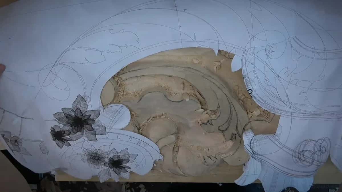 The paper pattern held over the board, with a window cut where the carved shell shows through
