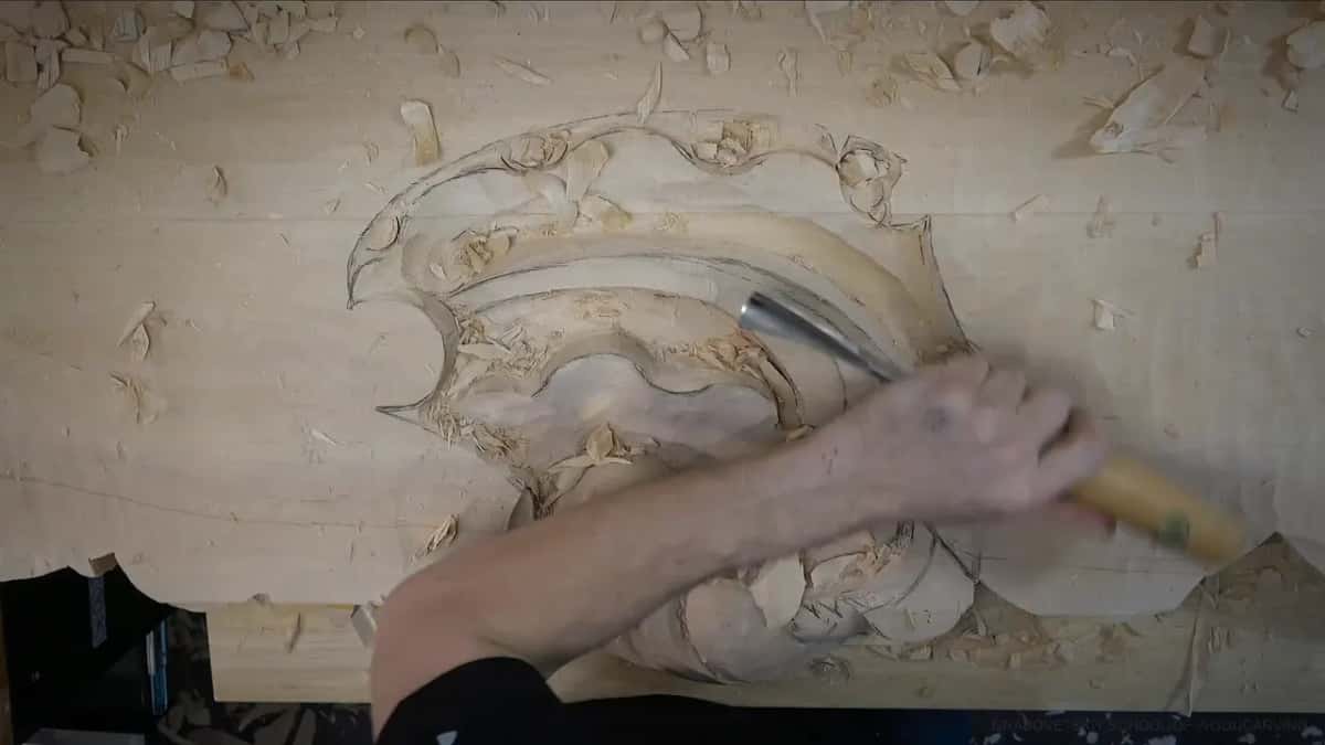 An arm reaches into the shell with a gouge